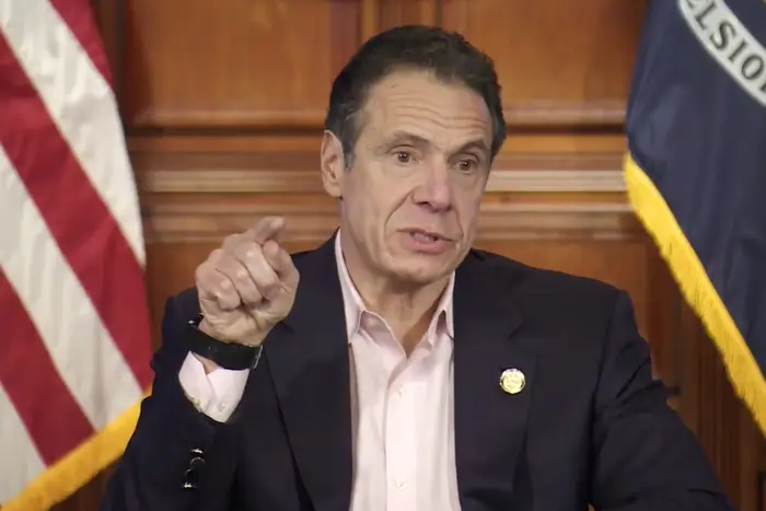 Governor Cuomo, sitting in the executive room in Albany, points his finger